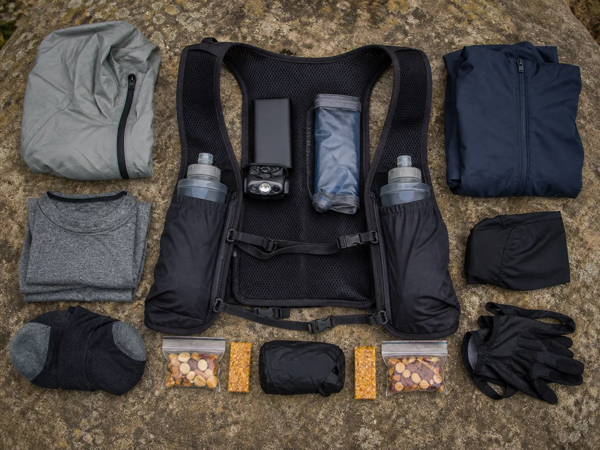 Material de trail running distribuido junto a un chaleco, con los objetos densos cerca de la espalda